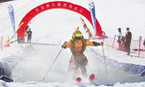 5月1日，萬(wàn)龍滑雪場(chǎng)第七屆“百龍過江”活動(dòng)現(xiàn)場(chǎng)，一名選手滑過水池。