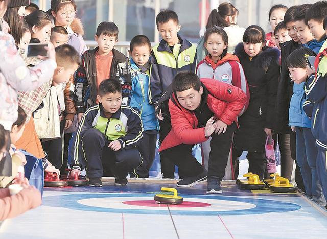 在省首屆冰雪運動會上，孩子們體驗陸地冰壺。
