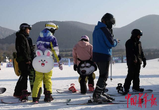 滑雪愛好者保持間隔排隊等待坐索道上山